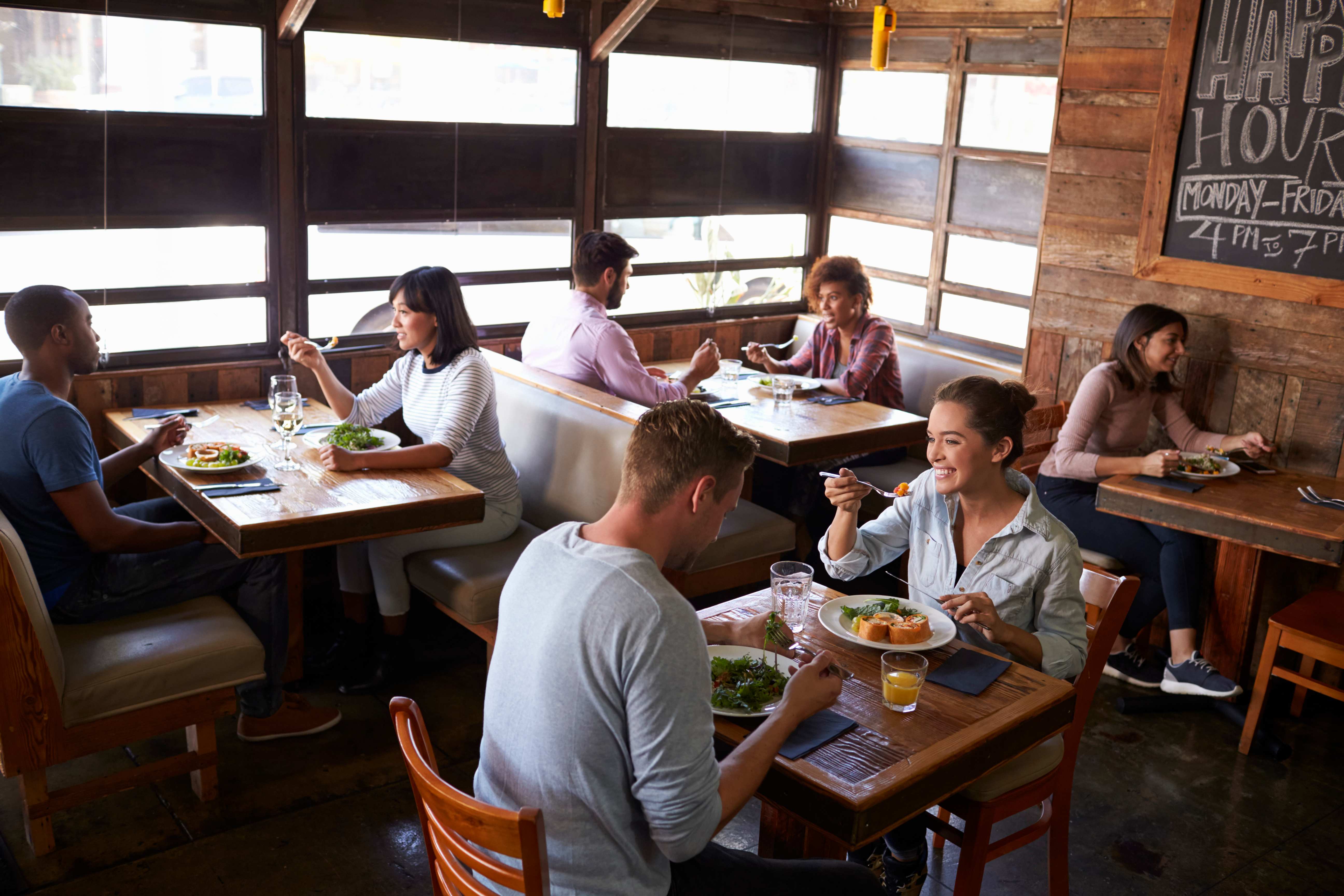 Happy customers dining in a casual restaurant representing the dining experience that restaurant insurance helps protect