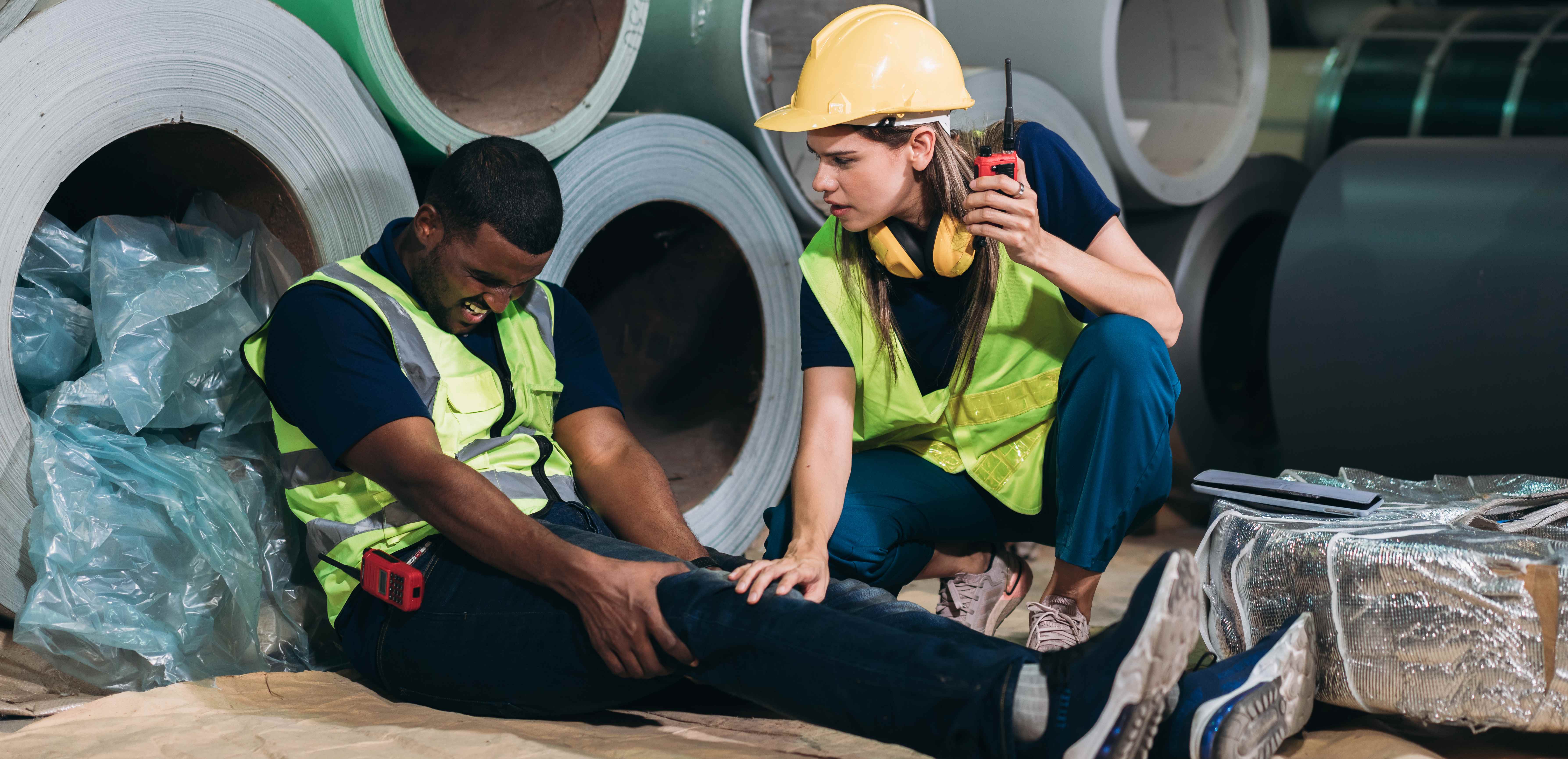 Industrial workers in safety gear responding to workplace accident, demonstrating the importance of workers compensation insurance coverage for employee injuries and workplace safety